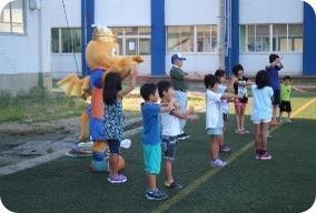 子供たちのラジオ体操参加率を高めたい Japanサッカーカレッジの人工芝グラウンドで 地元小学生と一緒にラジオ体操 ミニサッカー 4回参加すると学生たちからプレゼントも Nsgグループ