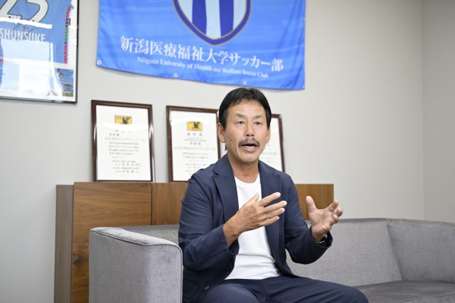 インタビューに応える新潟医療福祉大学男子サッカー部・佐熊裕和監督