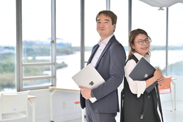 ほほえむ開志専門職大学の淡路 雅博さんと社会連携推進課 課長の谷内田 真理さん