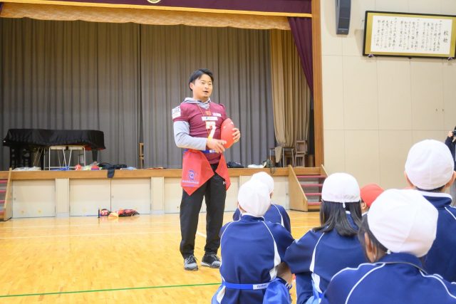 小学生にフラッグフットボールを教える小川さん